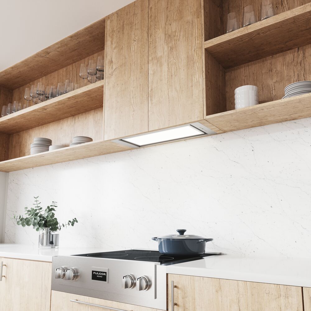 Modern kitchen with wood cabinetry featuring an integrated LED insert hood above a stove and marble backsplash