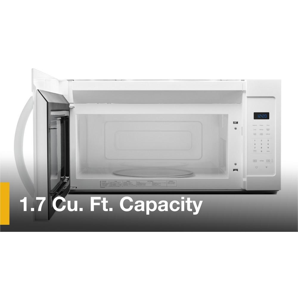 White microwave with open door, visible turntable, and digital touch controls in over-the-range kitchen appliance setting