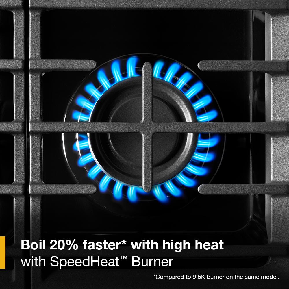 close-up of blue flame burning from black gas burner with cast-iron grate in kitchen appliances and ranges collection