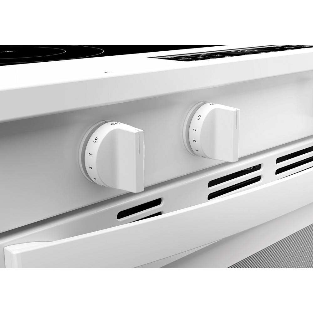 Close-up of white electric smart range control knobs and ventilation slots on a modern kitchen appliance panel