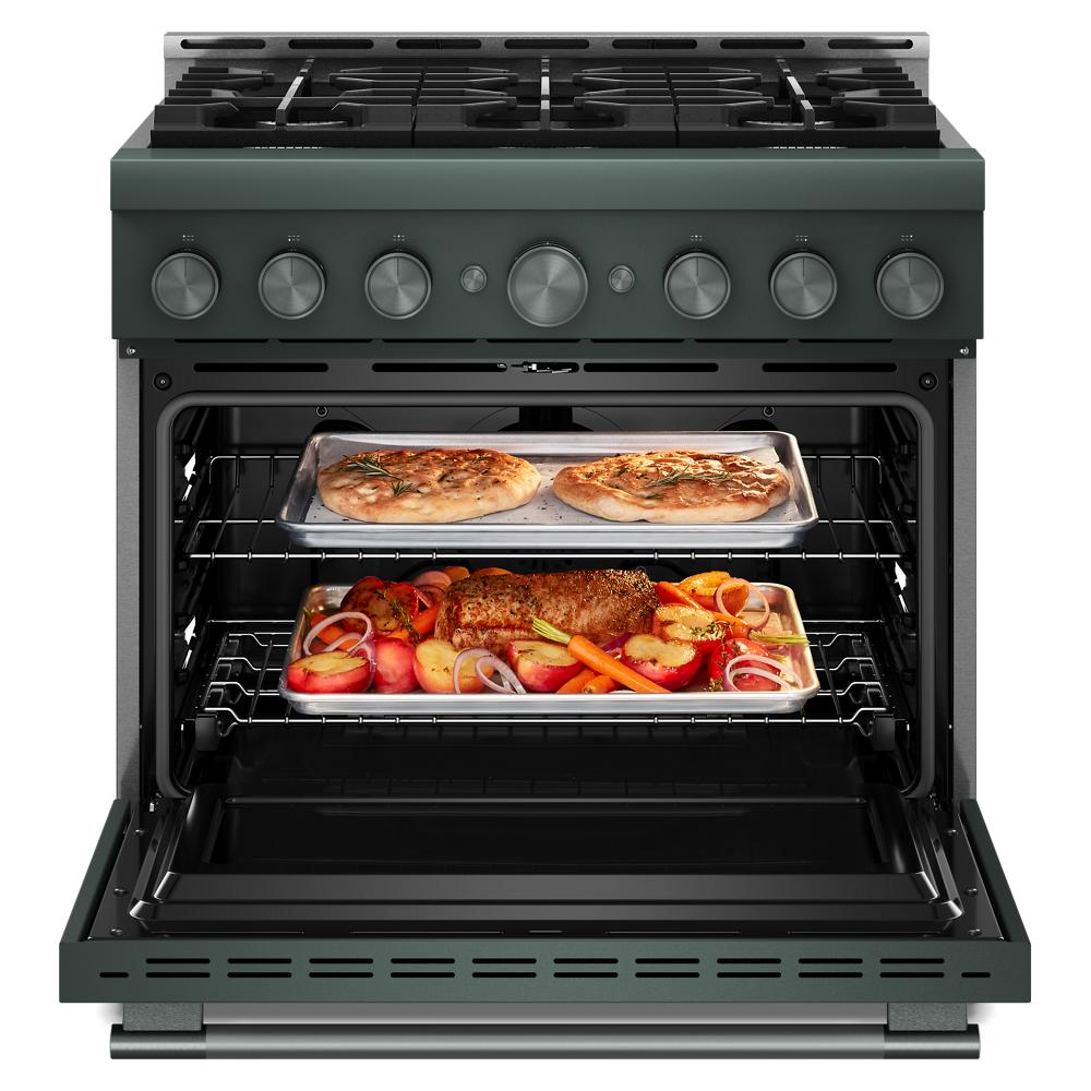 Open dark green commercial-style gas range with two trays of roasted vegetables and baked dishes inside oven cavity