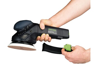Hands holding a black and green Festool power sander with detachable dust collection container for home improvement tools