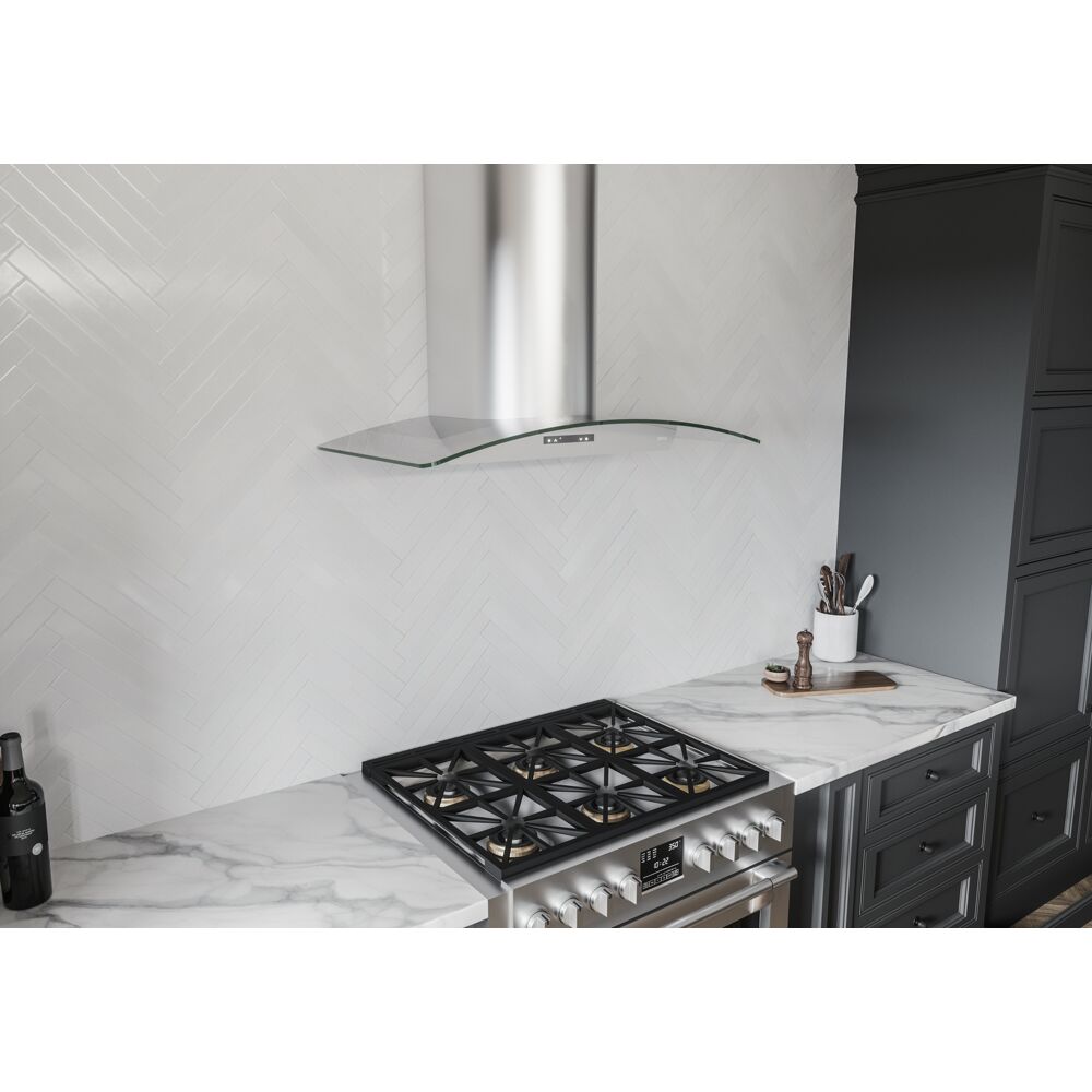 Contemporary stainless steel chimney hood with curved glass canopy above stainless steel gas cooktop in kitchen setting