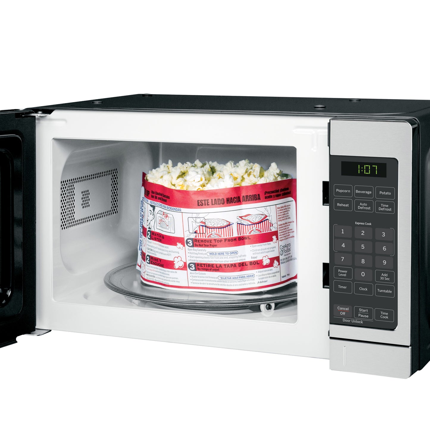 Countertop microwave oven with open door heating a popcorn bag, control panel with digital display and buttons visible