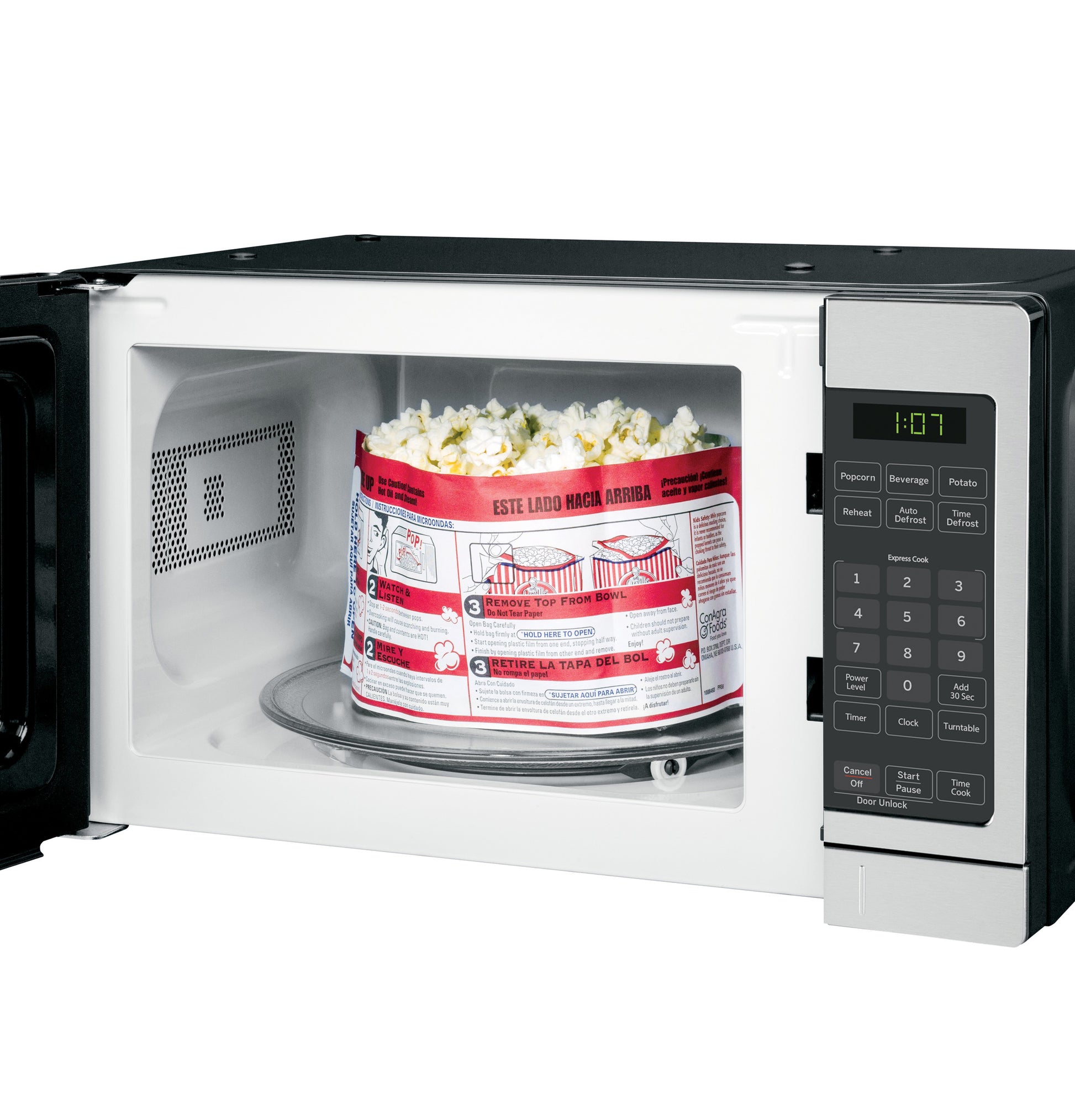 Countertop microwave oven with open door heating a popcorn bag, control panel with digital display and buttons visible