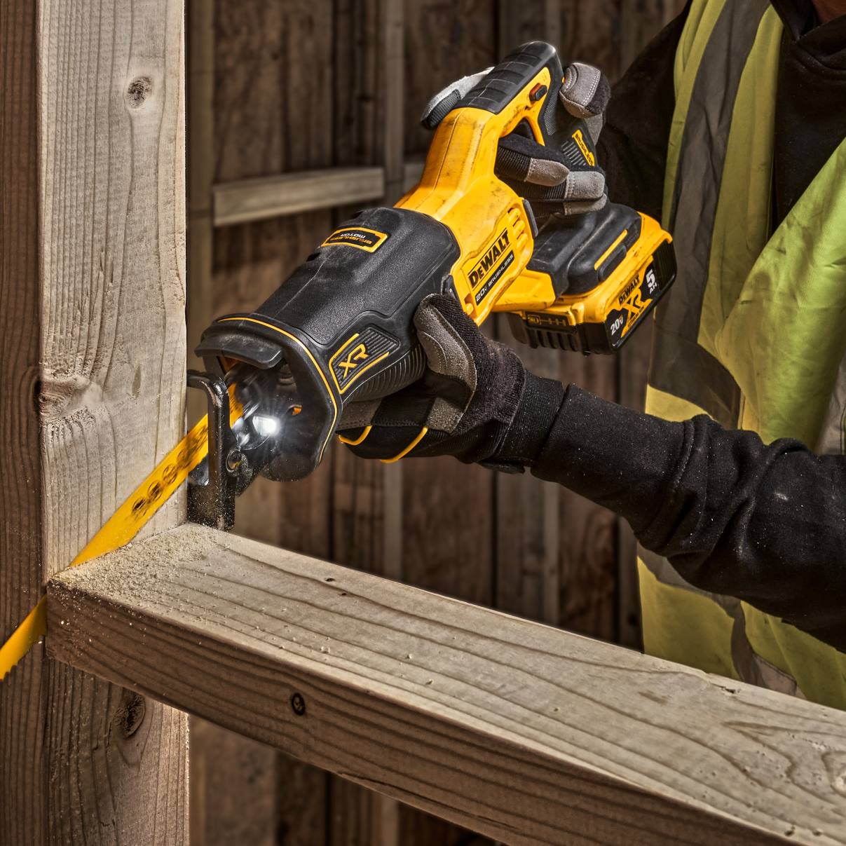 Worker using DEWALT 20V MAX XR brushless cordless reciprocating saw cutting wooden beam in home improvement project