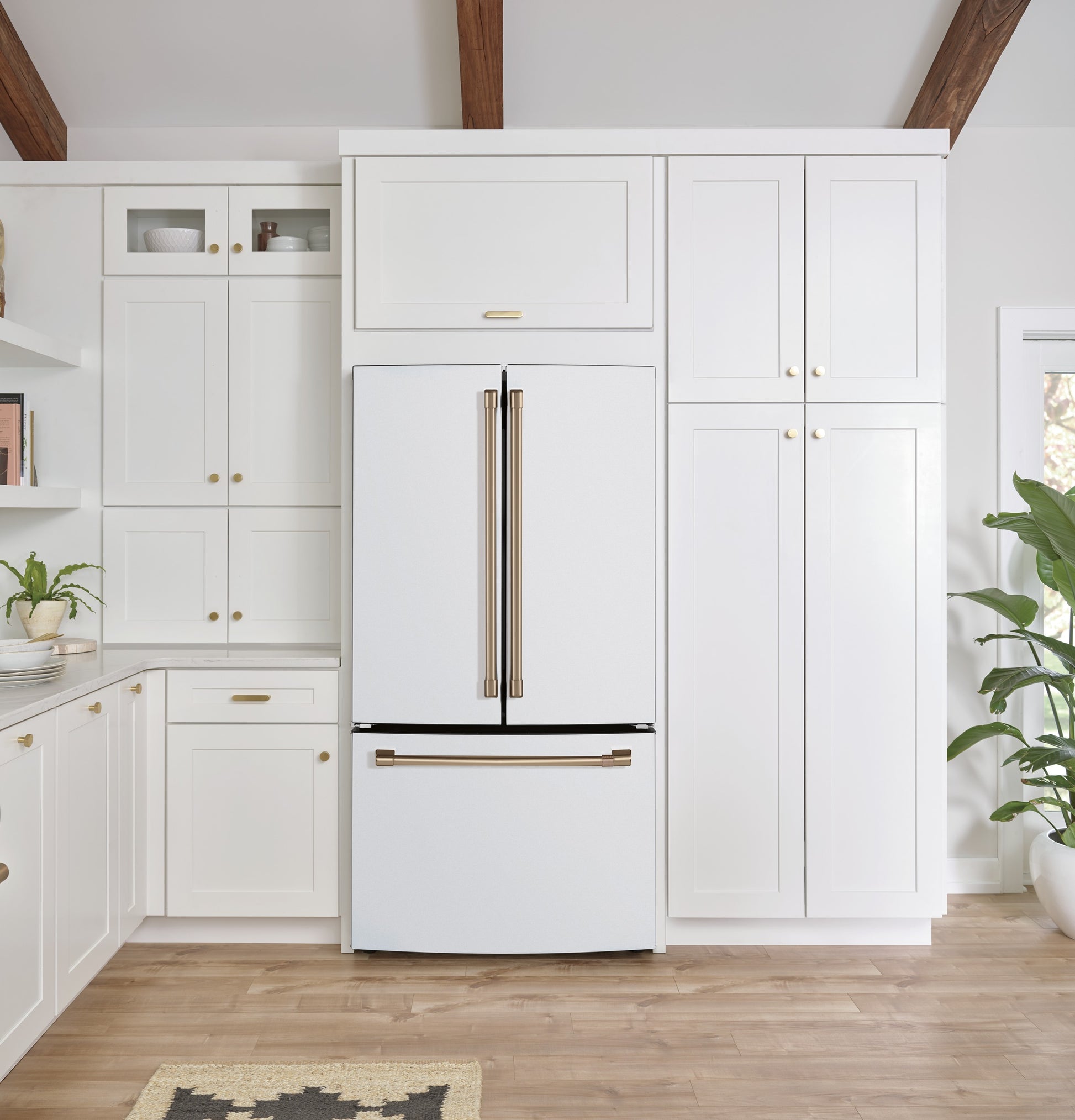 White counter-depth French-door refrigerator with bronze handles and bottom freezer in modern kitchen setting