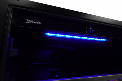Interior view of illuminated beverage center with digital thermostat and blue LED lighting in Appliances collection