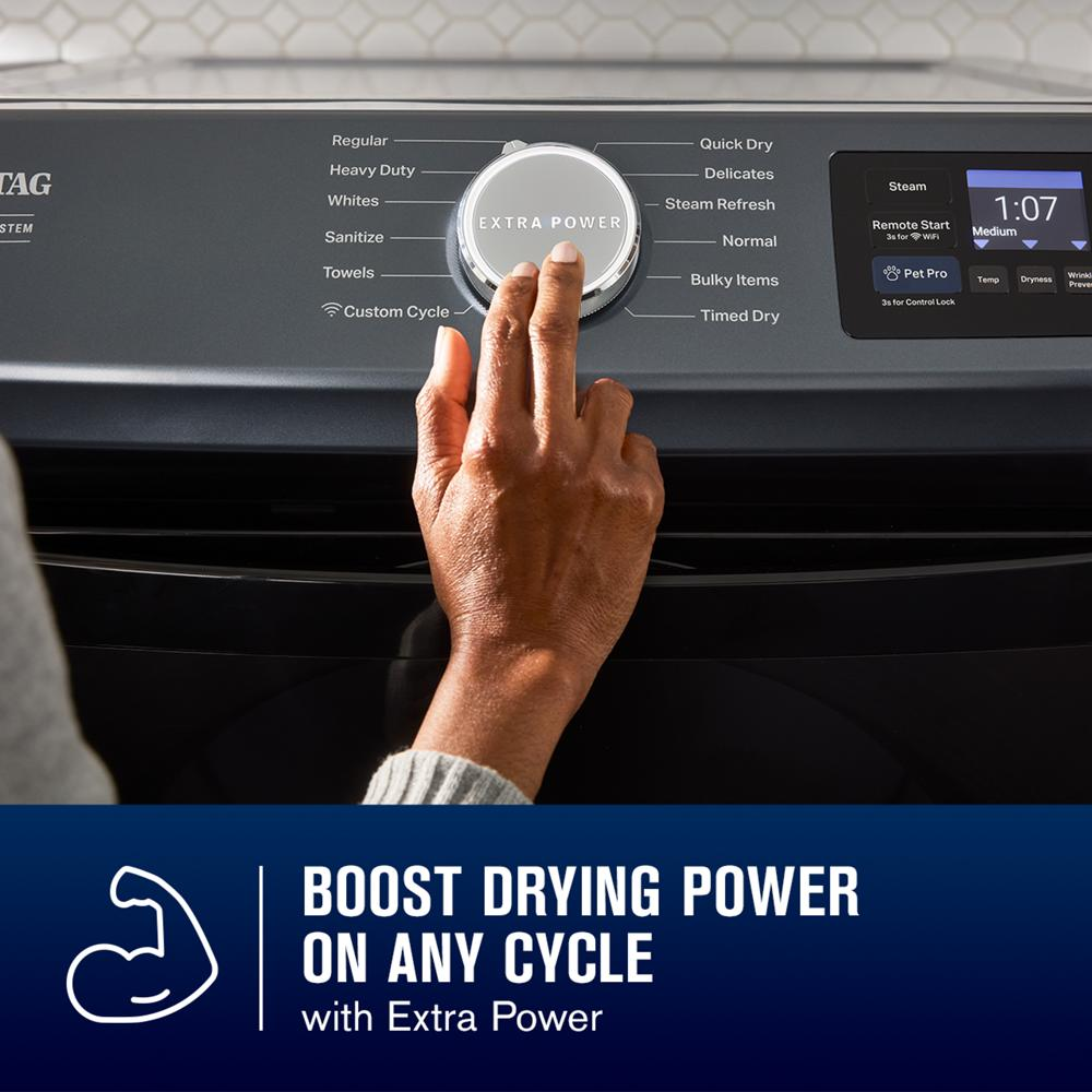 Hand adjusting cycle selector knob with Extra Power setting on a modern front load electric dryer in dryers collection