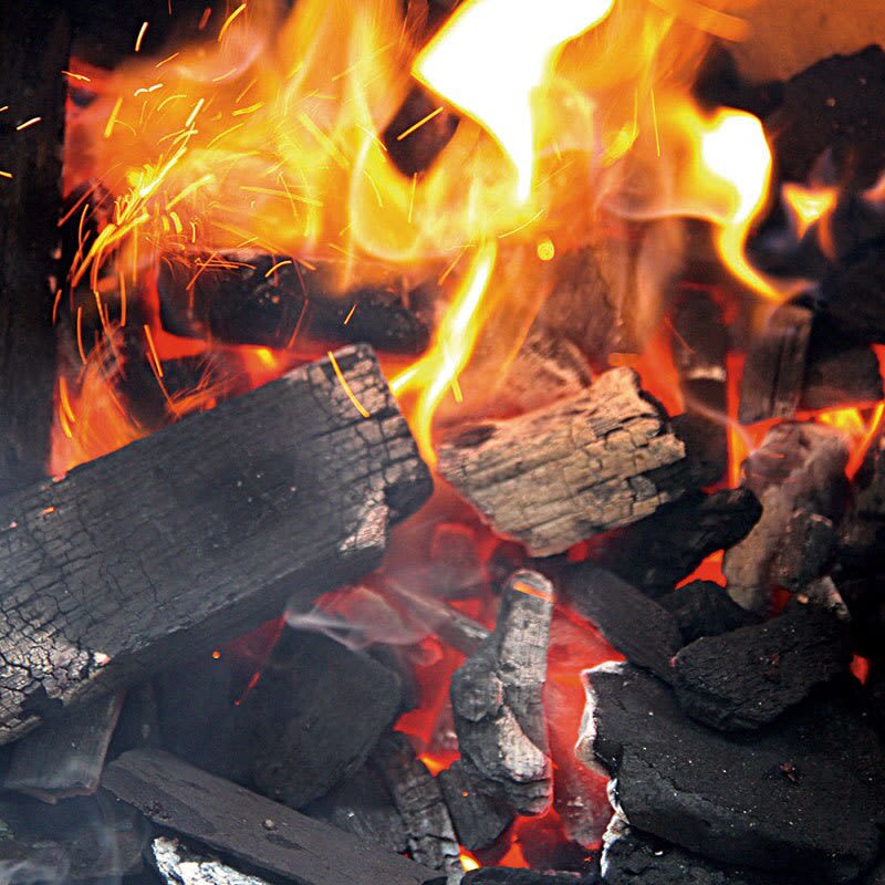 Burning oak and hickory lump charcoal with bright flames for grilling in outdoor living and lawn and garden use