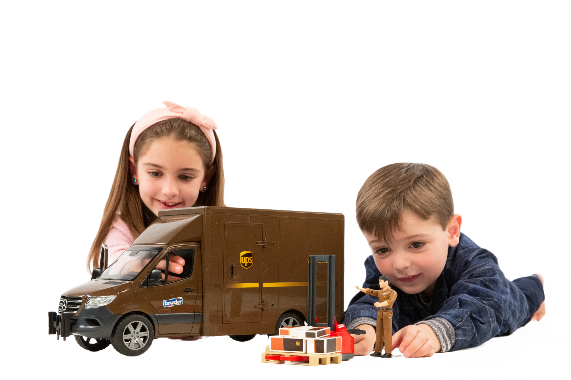 Children playing with brown model UPS delivery van, driver figure, pallet jack, and packages from Bruder Toys collection
