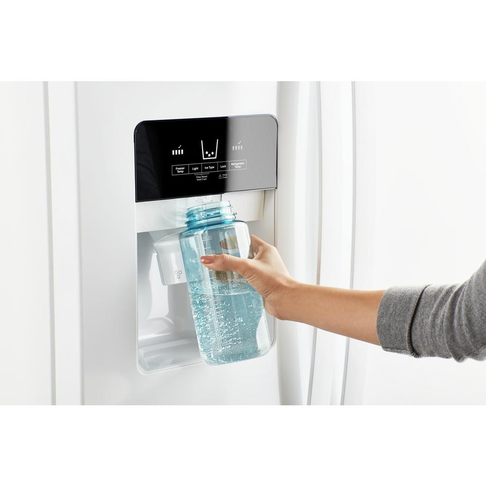 Person filling clear reusable bottle with water from digital control dispenser on white side-by-side refrigerator in kitchen appliances collection