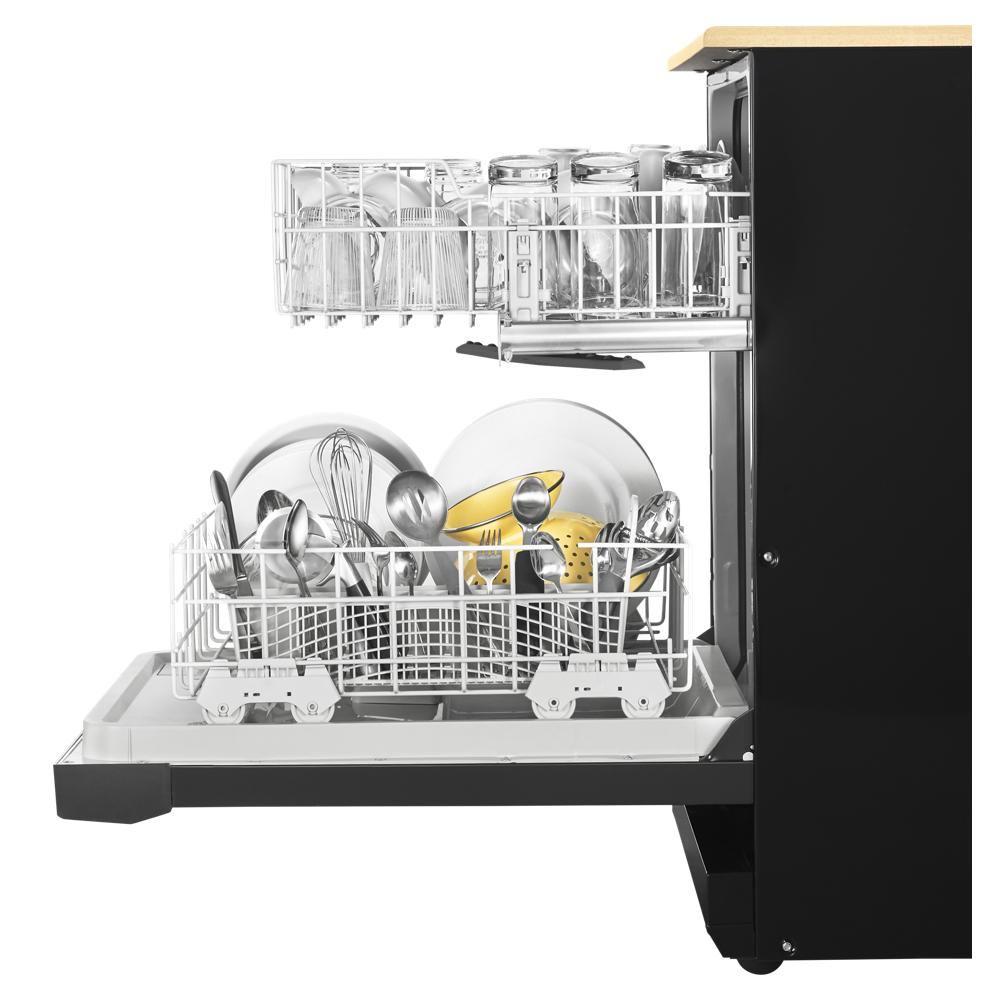 Open black dishwasher filled with clean kitchen utensils, plates, and glassware from modern kitchenware collection