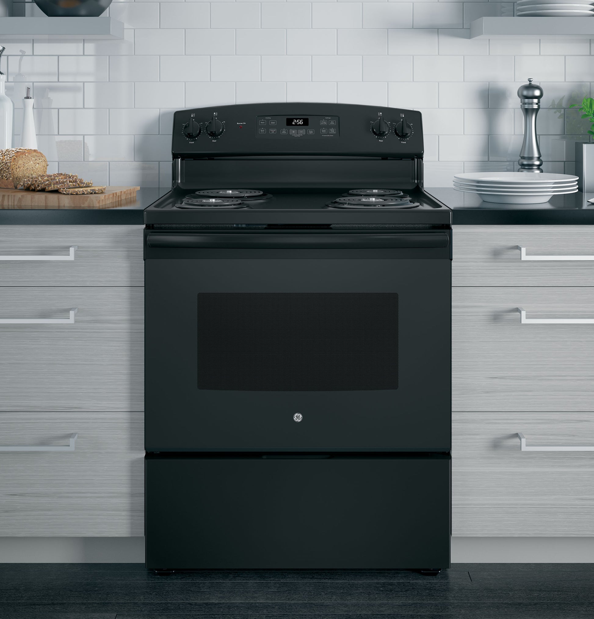 Black freestanding electric range with control knobs and digital display in modern kitchen setting