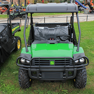 Green off-road utility vehicle with protective roof and rugged tires designed for heavy-duty outdoor work tasks