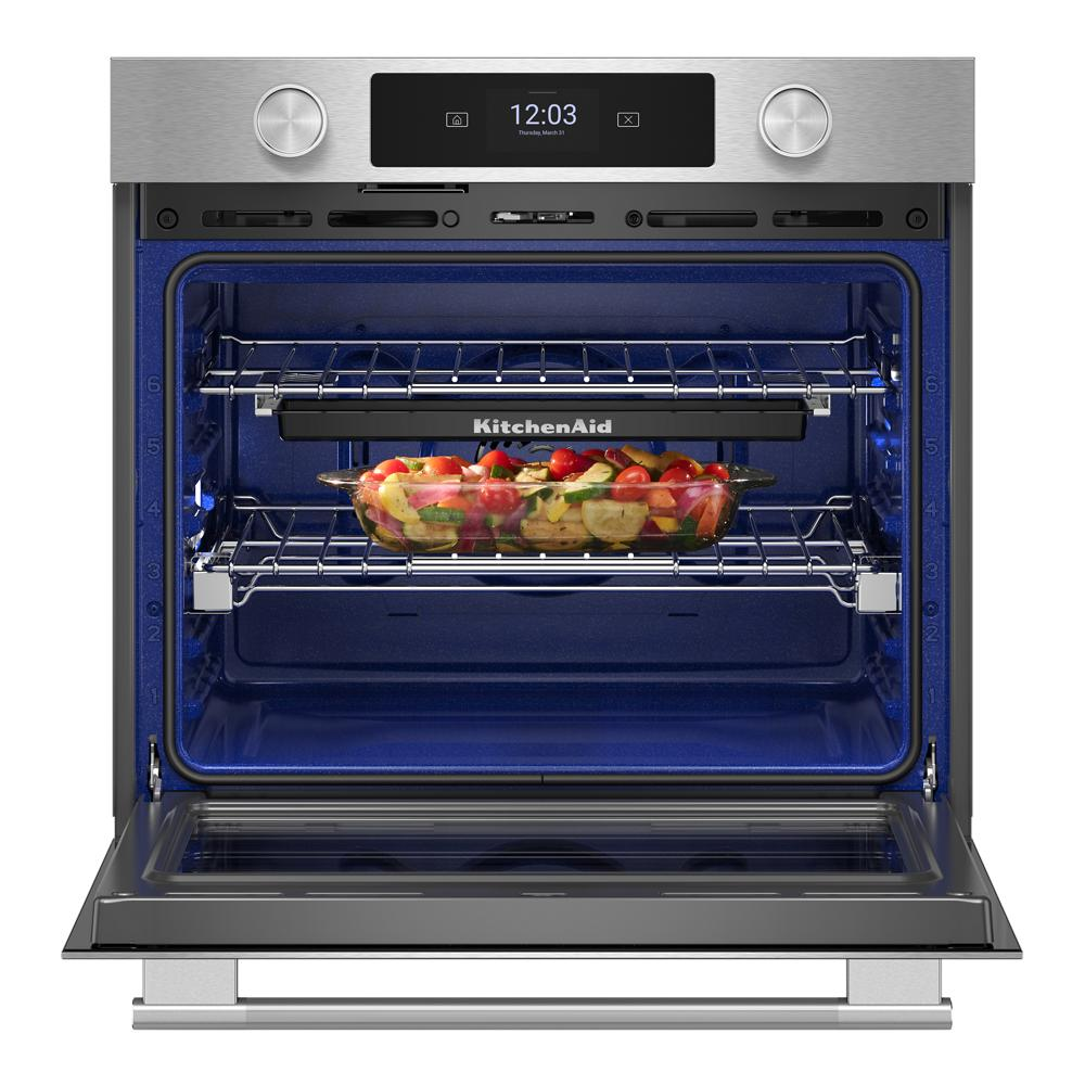 Open smart electric single wall oven with vegetables roasting on middle rack in modern kitchenware collection setting