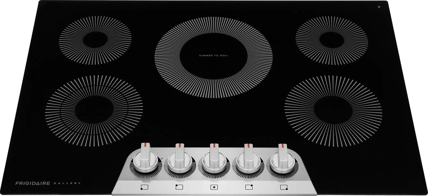 Black electric cooktop with five circular radiant heating elements and front-mounted metal control knobs in kitchen appliances collection