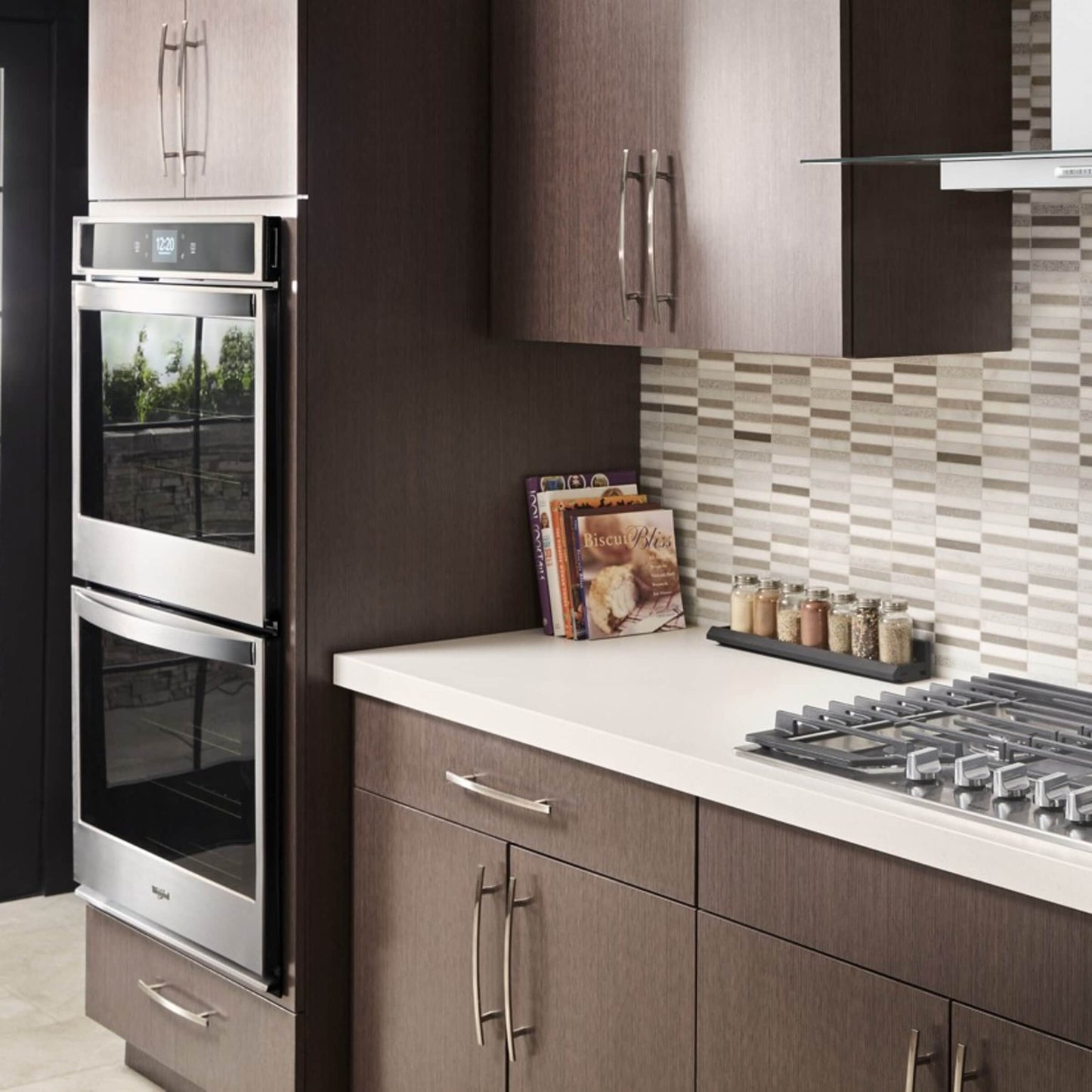Modern kitchen corner with built-in stainless steel double wall oven, gas cooktop, and tiled backsplash from Appliances collection