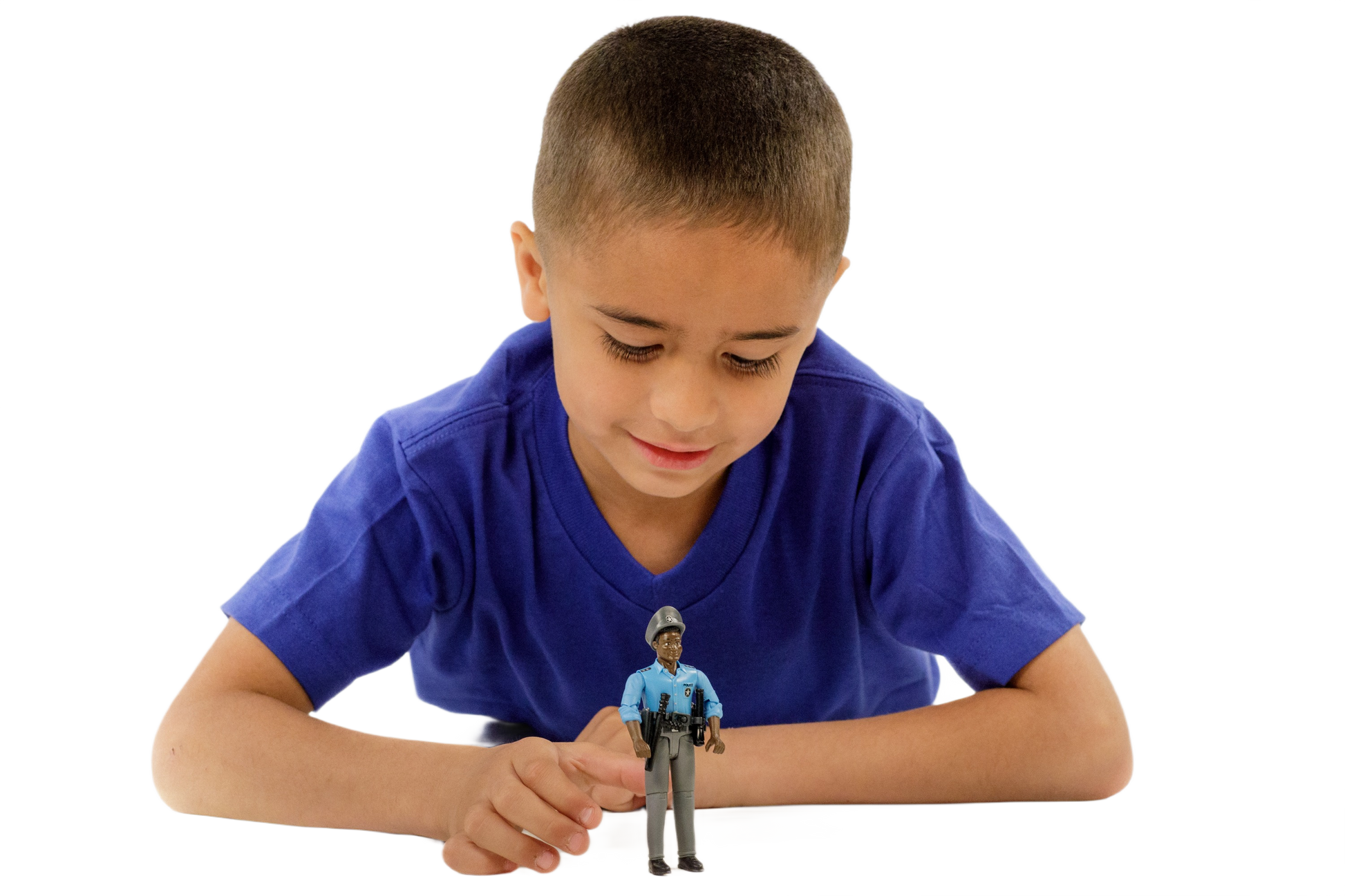 Boy in blue shirt playing with a dark-skinned policeman toy figure dressed in a detailed blue uniform and cap