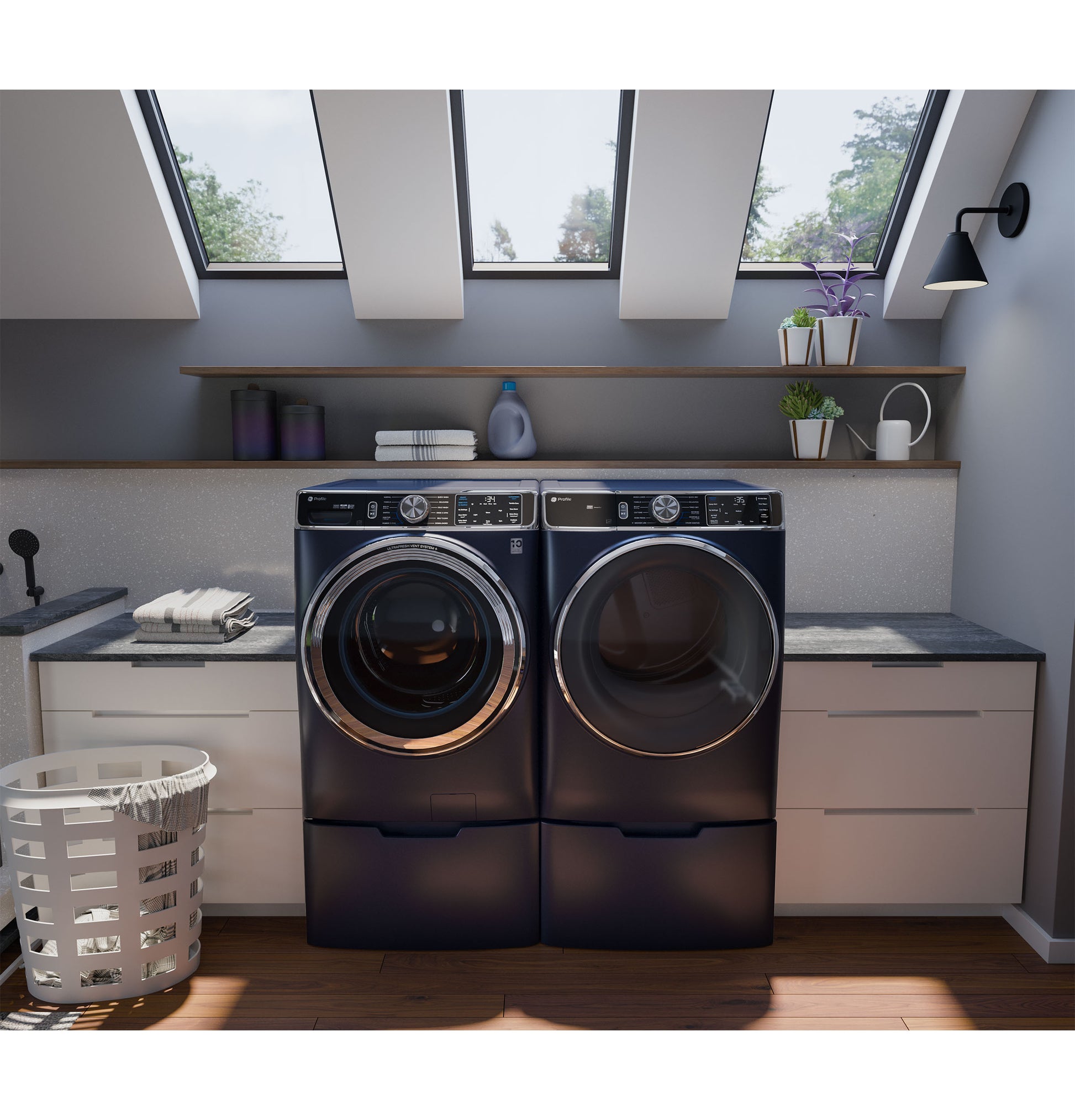 Modern laundry room with dark blue front load washer and dryer in built-in white cabinetry under skylights in appliance setting