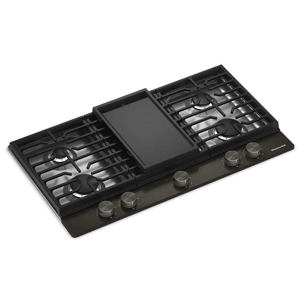 Angled view of a black gas cooktop with five burners, integrated griddle plate, and metal control knobs, part of Cooktops, Gas Cooktops, Kitchen & Kitchenware, All Products, KitchenAid, Appliances, and Ranges & Cooktops collections.