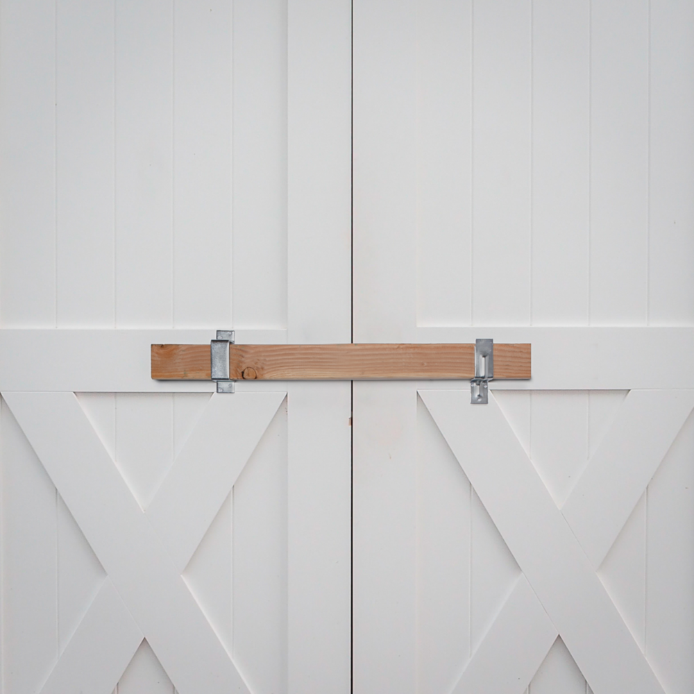 Zinc-finished heavy duty open bar holder securing 2x4 lumber on white barn doors for gate hardware and home improvement projects