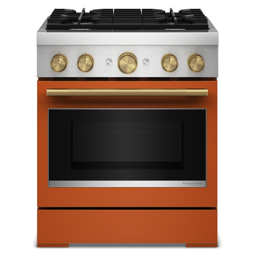 Front view of orange and stainless steel dual fuel range with brass knobs and four gas burners in kitchenware setting