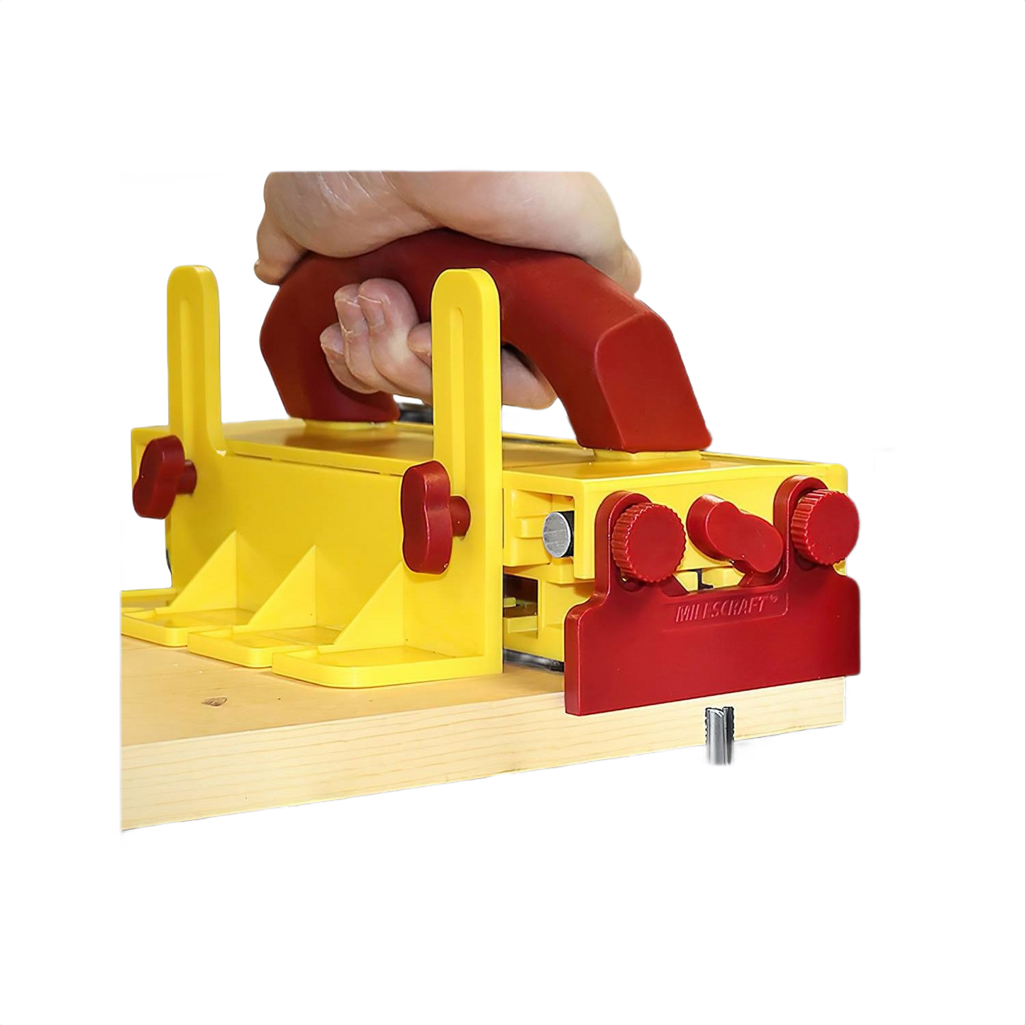 Hand gripping yellow and red adjustable multi-purpose push block securing wood for precise woodworking and home improvement tasks