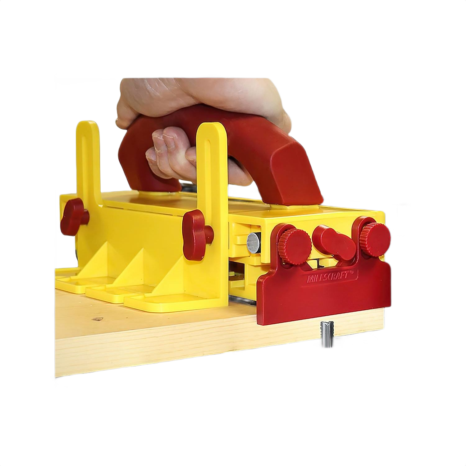 Hand gripping yellow and red adjustable multi-purpose push block securing wood for precise woodworking and home improvement tasks