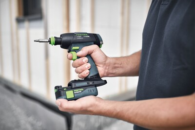 Person holding Festool cordless drill with Li-Ion battery and FastFix interface in woodworking and power tools setting