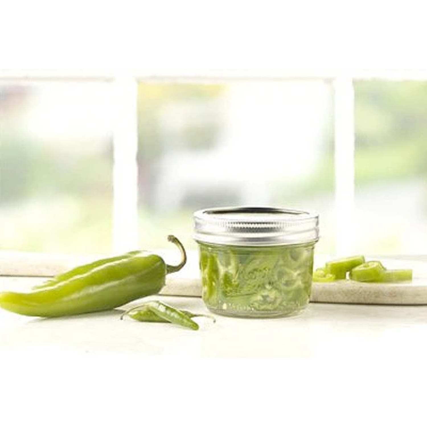 Clear glass wide mouth half-pint jar with metal lid holding sliced green peppers in kitchenware under $50 collection