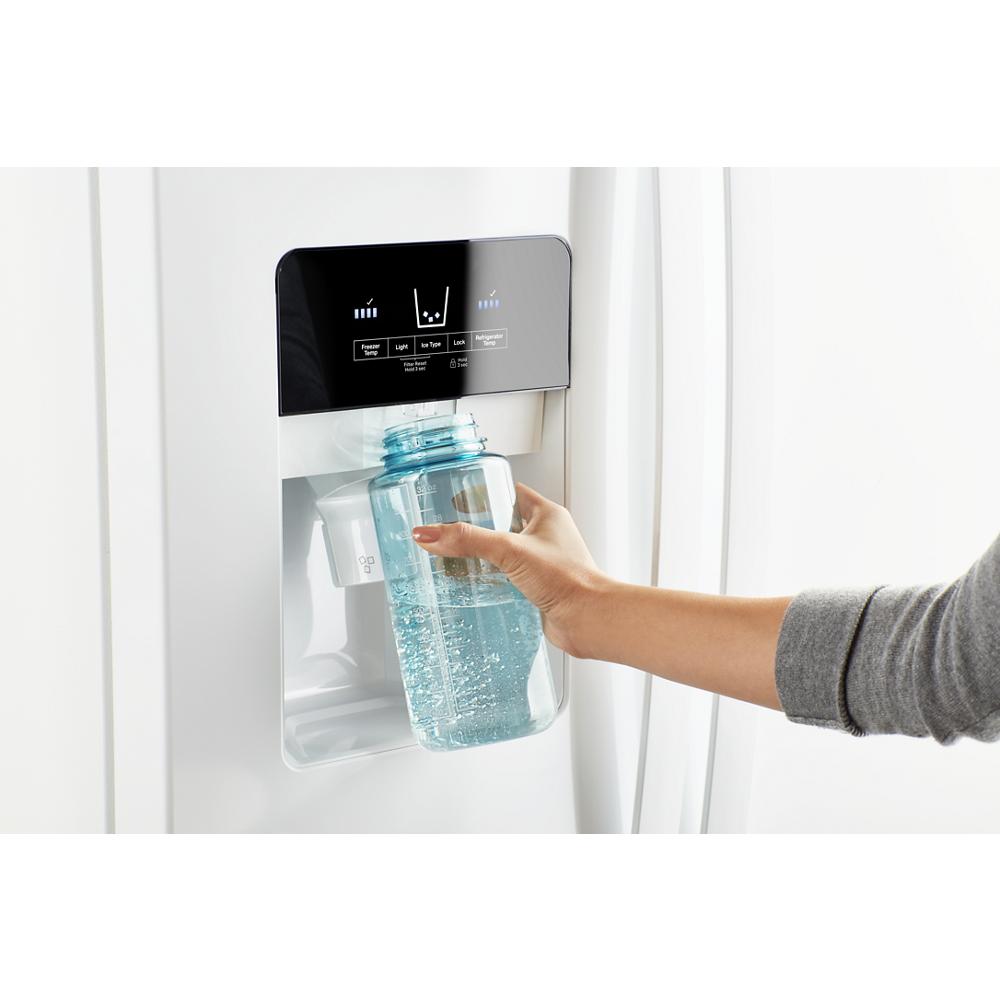 Hand filling reusable water bottle from built-in dispenser on modern white side-by-side refrigerator in kitchen appliances collection