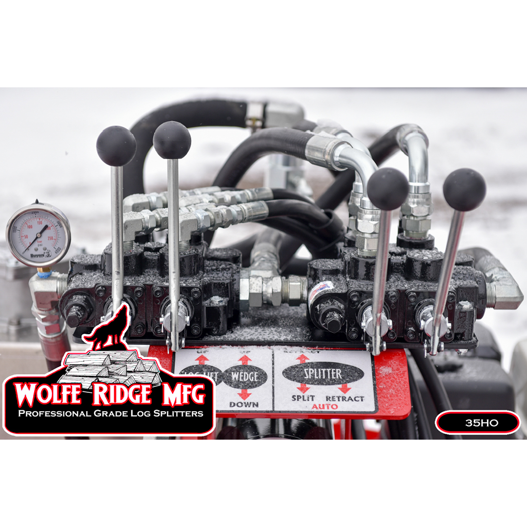 Close-up of hydraulic control levers, pressure gauge, and valve assembly on Wolfe Ridge log splitter with snowy background