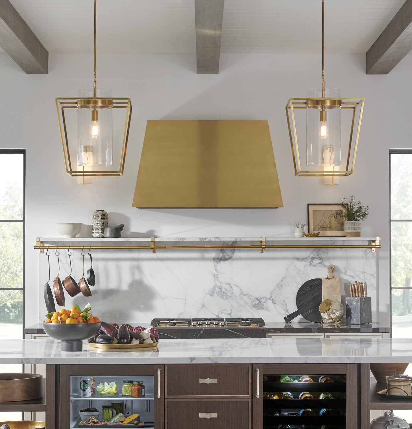 Brass kitchen hood above marble backsplash with modern pendant lights in kitchen and home improvement collections