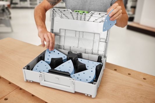 Open gray Festool Abrasives Systainer with organized blue sanding sheets for power tool accessories in tool collections
