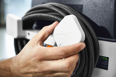 Hand securing power cord on Festool woodworking dust extractor from dust collectors and air filtration tools collection