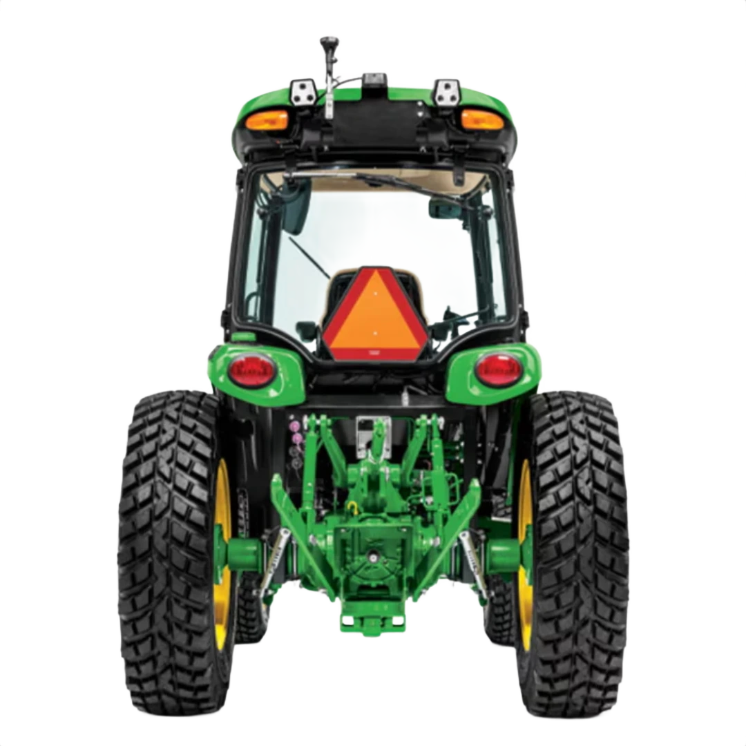 Rear view of green John Deere 4075R Compact Tractor with ComfortGard cab, large rugged tires, and safety slow-moving vehicle triangle, in Outdoor Power Equipment at Hartville Hardware.