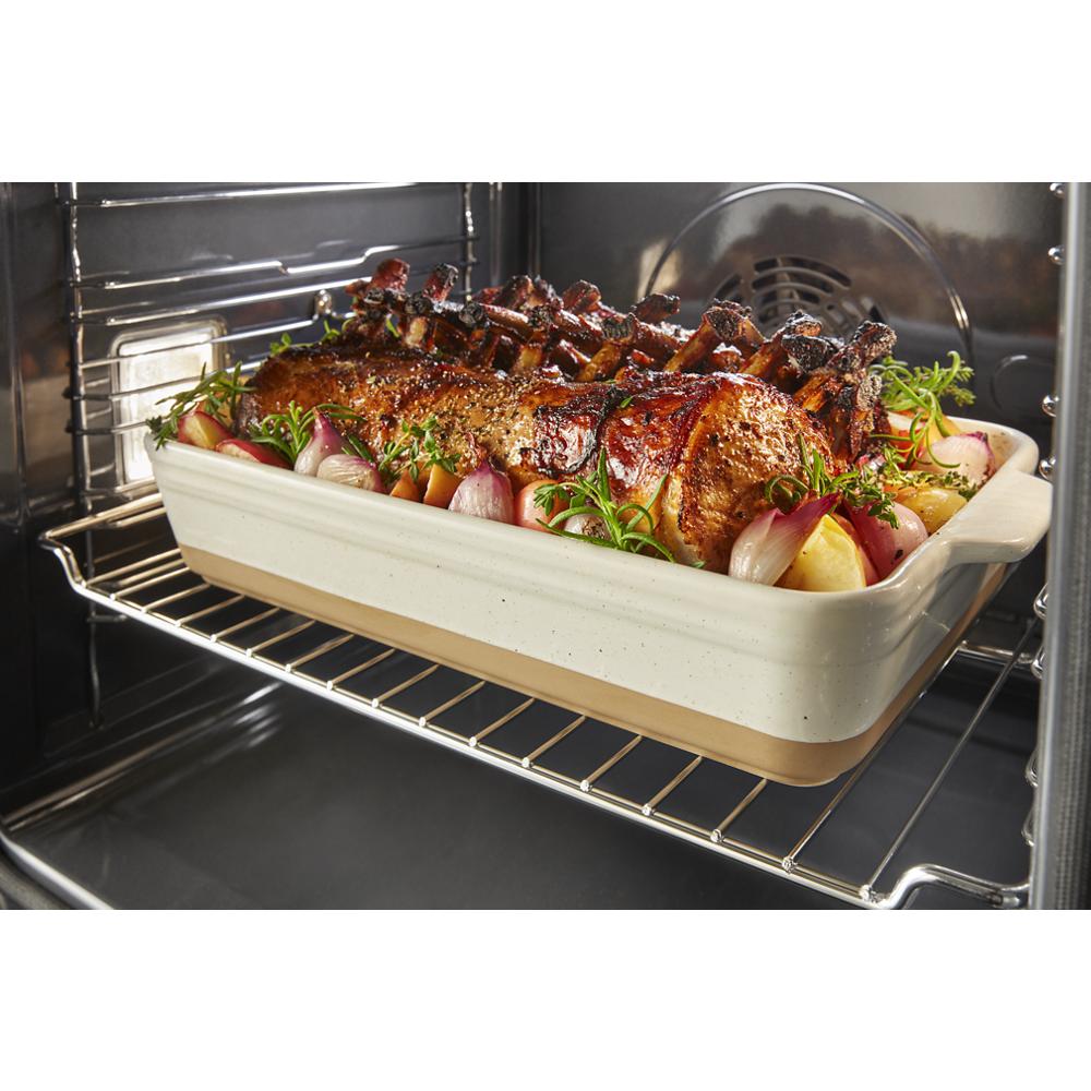 Roast meat with vegetables cooking inside a stainless steel smart single wall oven with convection fan visible