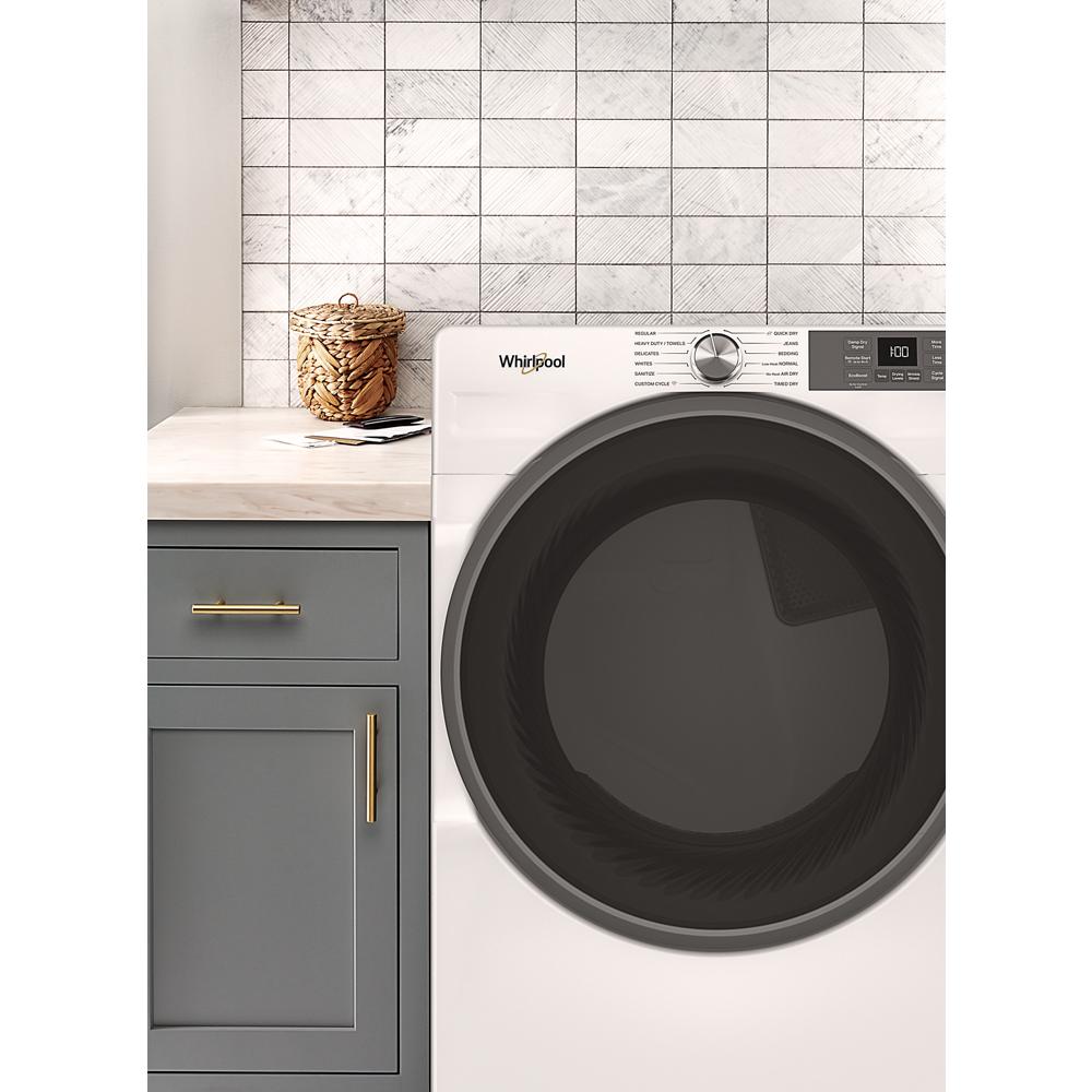 White front load electric dryer with large black door and digital control panel in modern laundry room setting