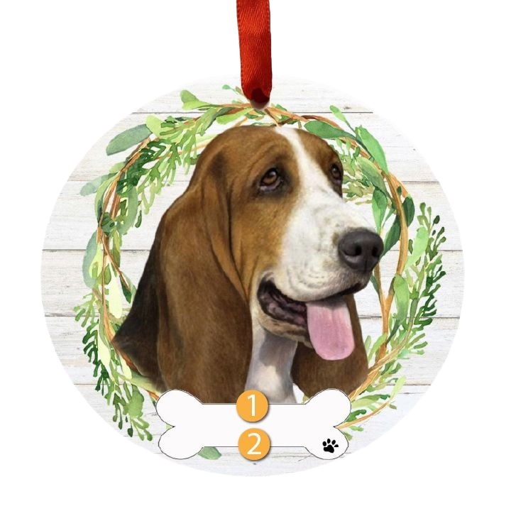 Round Christmas ornament with a smiling Basset Hound face surrounded by a green wreath on wood background