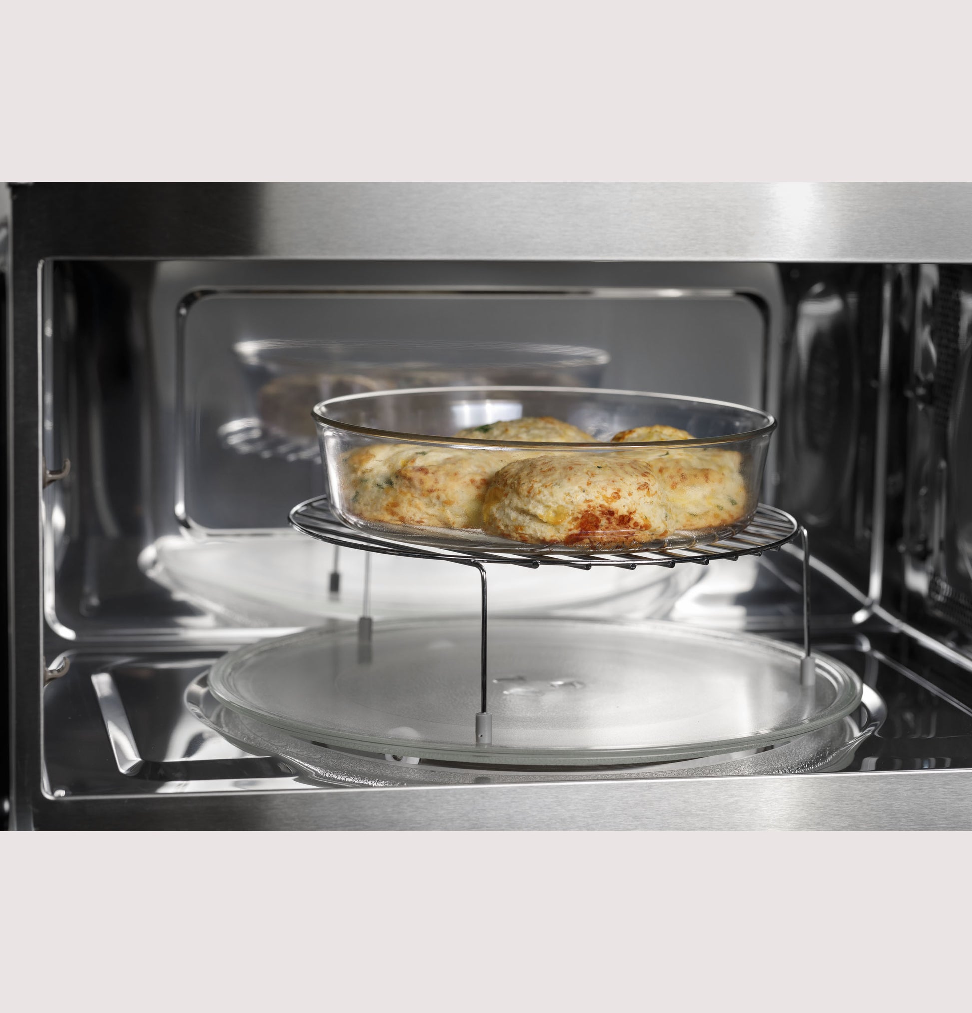 Glass baking dish with baked biscuits inside a stainless steel built-in microwave convection oven from kitchen appliances collections