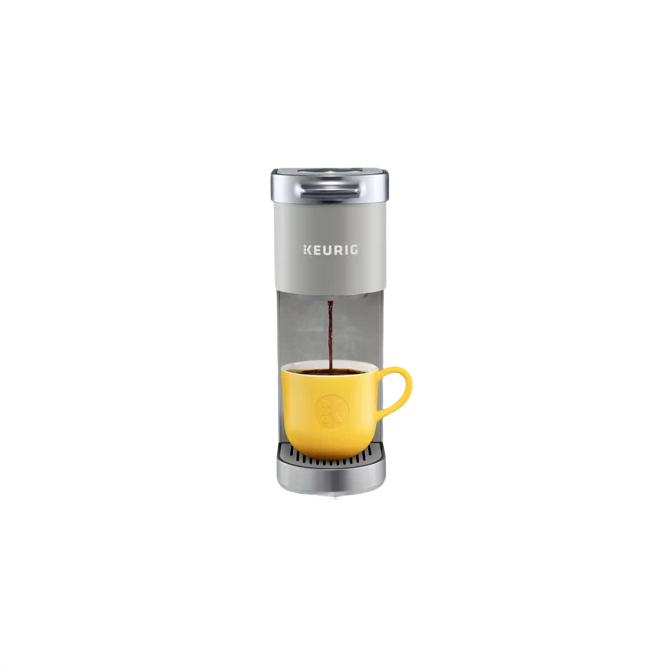 Compact studio gray single-serve coffee maker brewing coffee into a yellow ceramic mug for home use