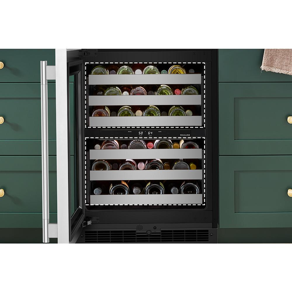 Undercounter beverage cooler with metal racks storing cans and bottles, built into green kitchen cabinetry with brass hardware