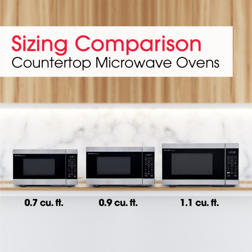 Comparison of three stainless steel countertop microwave ovens in varying sizes on a kitchen counter with wood background