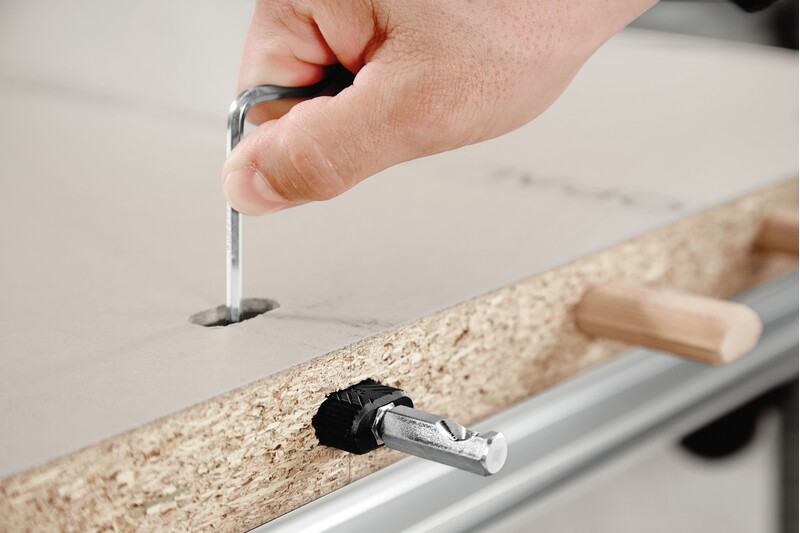 Hand using hex key to adjust Festool Domino Connector Extension Shell on particle board for woodworking tools accessories