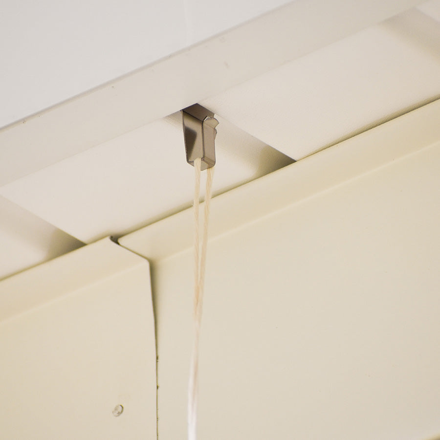 Metal soffit hook attached to outdoor soffit holding a cord for home improvement or hardware use