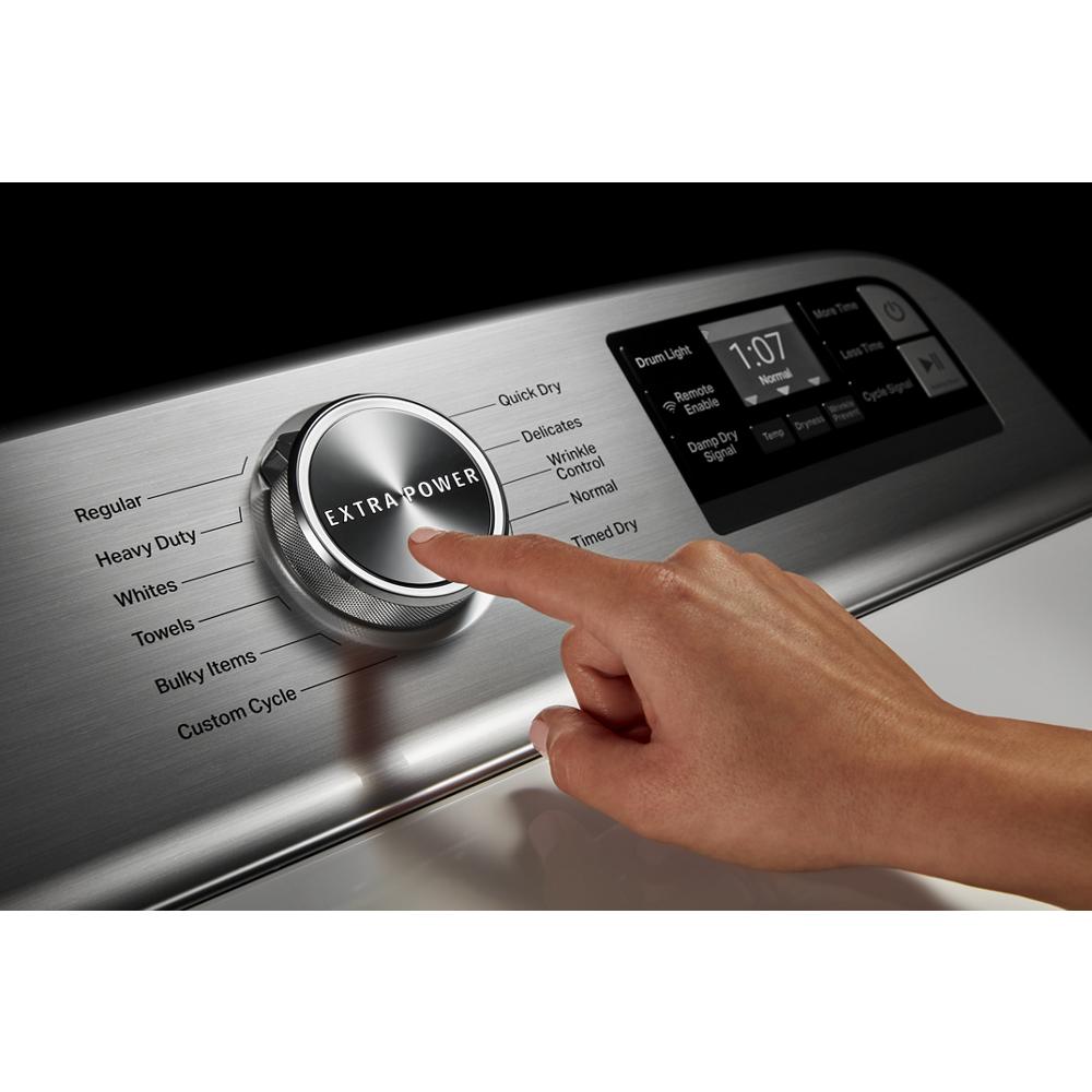 Hand pressing extra power button on stainless steel control knob with cycle options on electric dryer panel in Dryers collection
