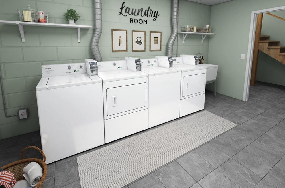 White commercial gas dryers with coin slide controls in a clean laundry room from dryers and gas dryers collection