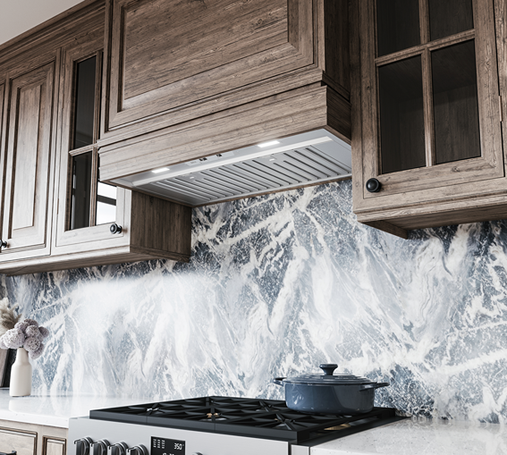 Under-cabinet hybrid baffle insert hood with LED lighting and mechanical controls above modern gas range in kitchen setting