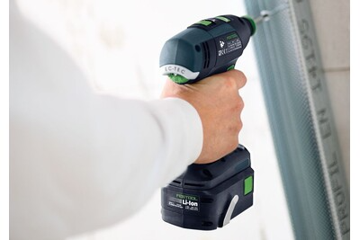 Person holding a compact cordless drill with ergonomic design for precision home improvement tasks and tool use